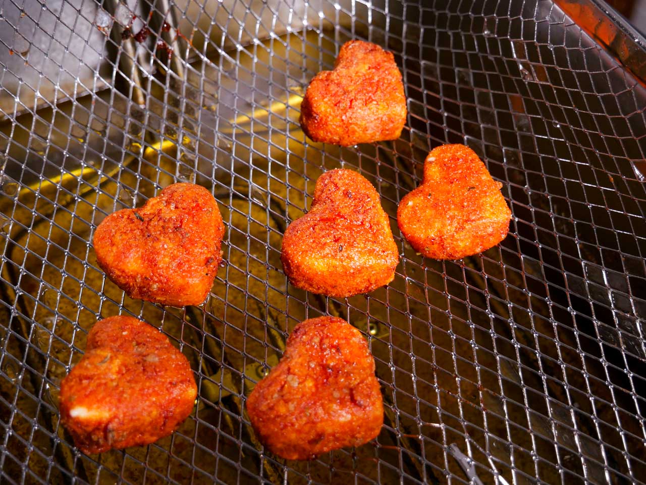 Heart-shaped Mozzarella Bites in a fryer basket 