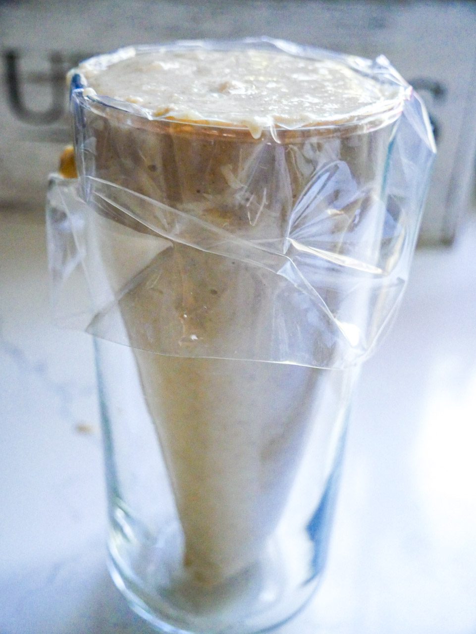 Piping bag in a tall glass filled with mini donut batter