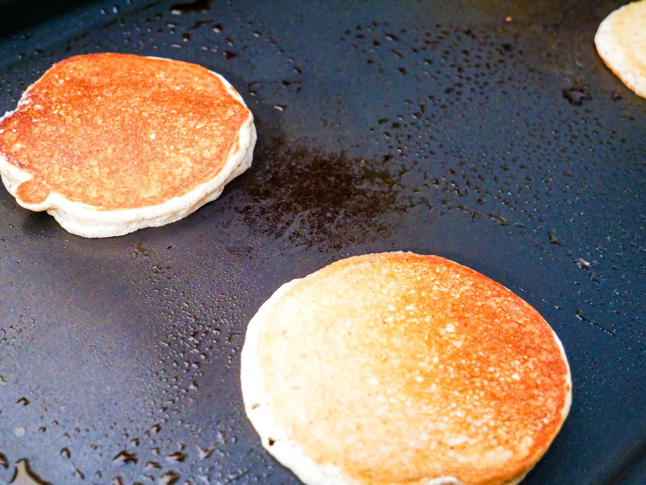 Two tiger nut flour pancakes on a griddle
