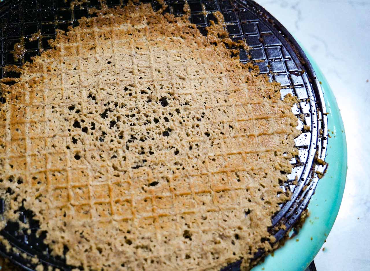 Homemade gingerbread on waffle iron before taco shell is formed