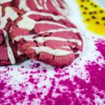 Vibrant magenta Dragon Fruit Cookies With Passion Fruit Glaze on a white plate